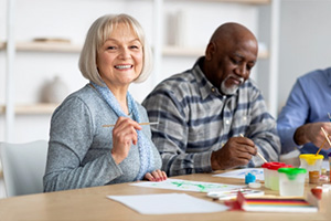 smiling elderly woman painting