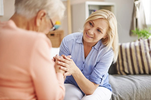 elderly resident sitting and talking with her middle-aged daughter