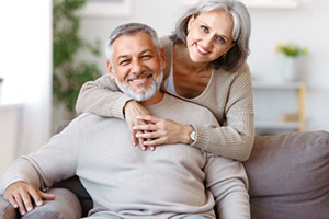 elderly couple smiling and hugging