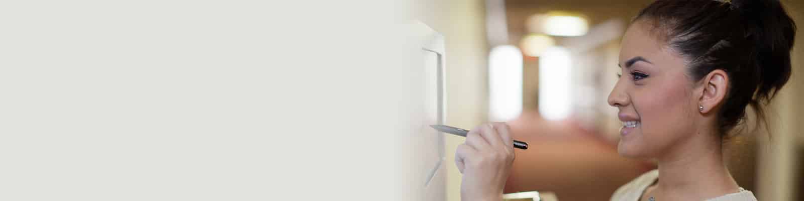 A nurse in the hallway at the nurse's electronic noteboard at the Redlands Healthcare Center