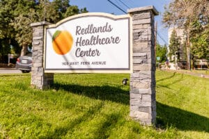 The welcome sign to Redlands Healthcare Center