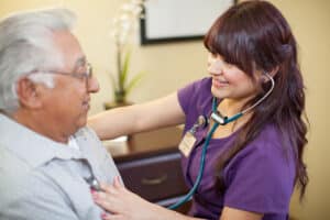 A nurse checking a patients vitals at Redlands Healthcare Center