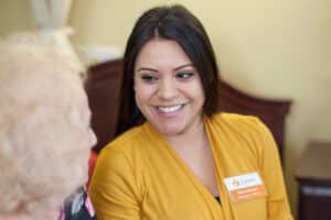 An employee chatting with an elderly woman at Redlands Healthcare Center