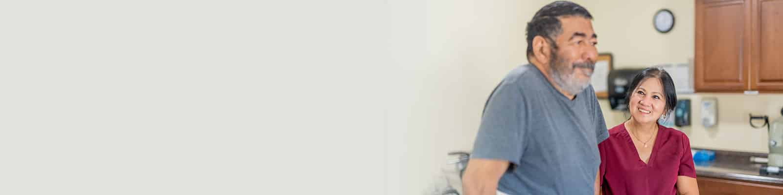 A rehab therapist with a resident in the rehab gym at Redlands Healthcare